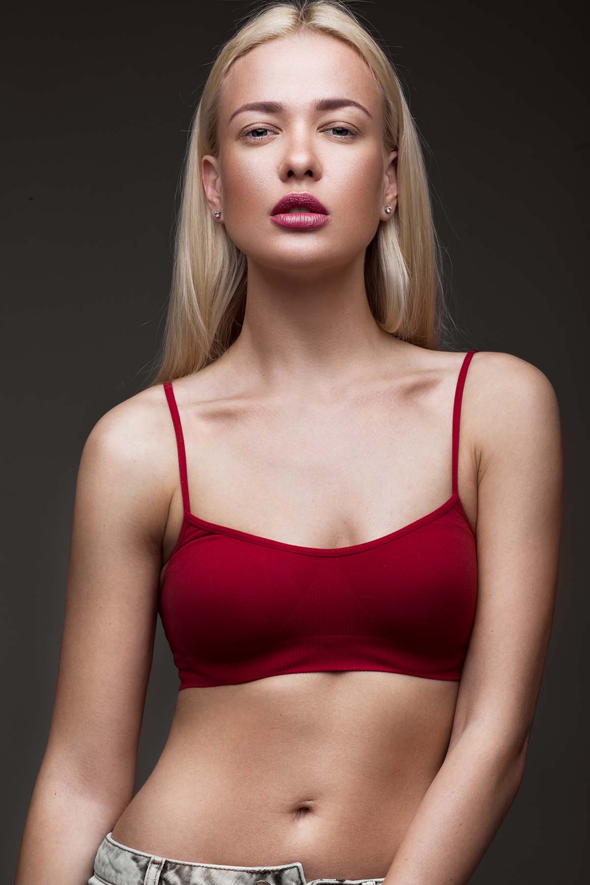slender confident young woman in red top Young woman embodying health and beauty from aesthetic treatments at Body Soul Nutrition.