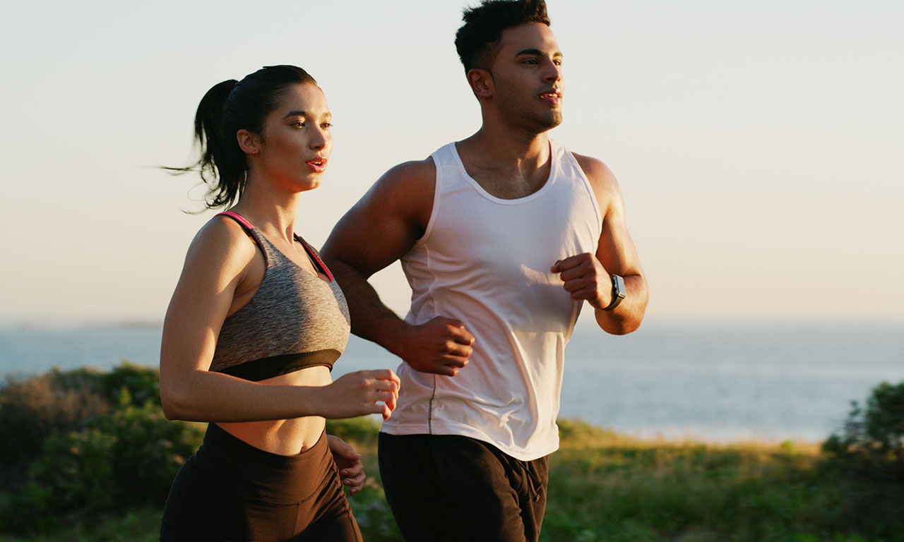 healthy athletic couple running at the beach Couple enjoying active wellness on the beach, reflecting a healthy lifestyle.